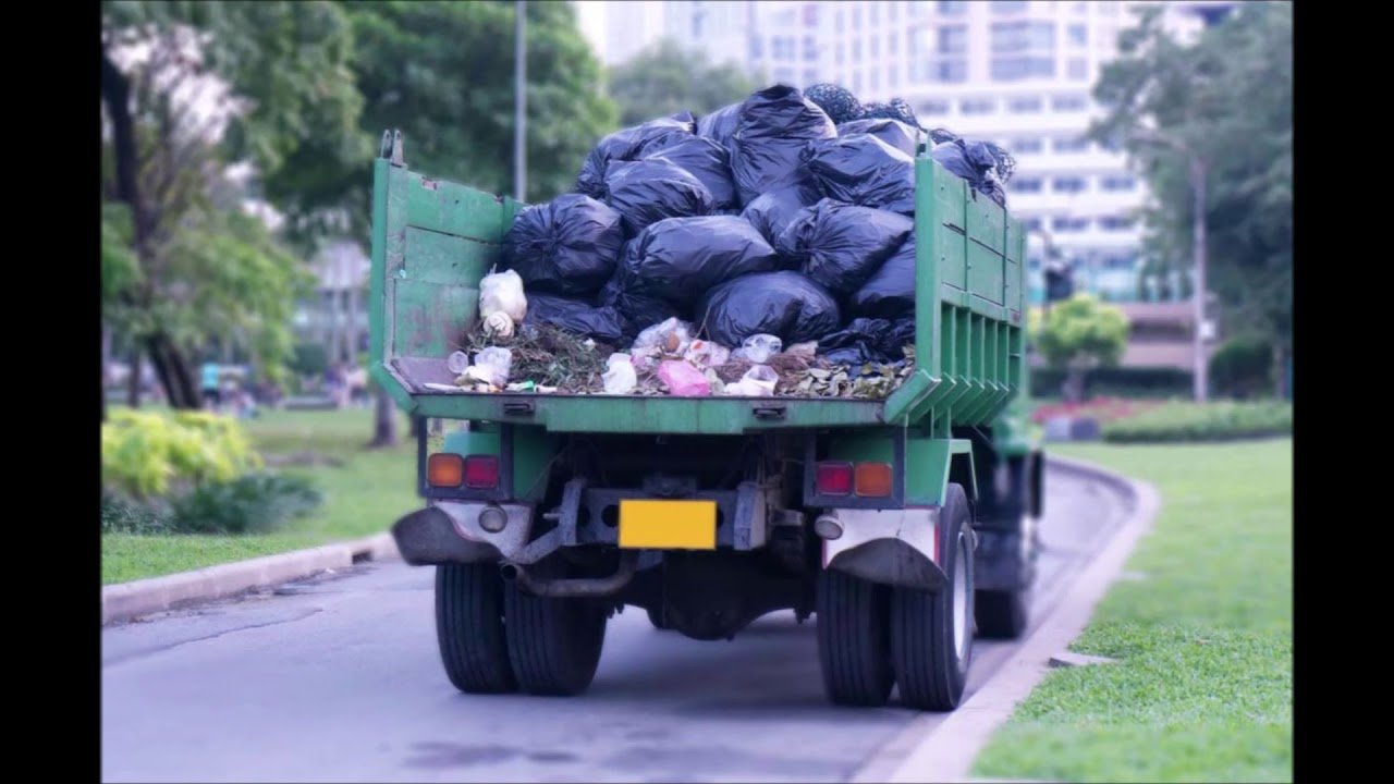 Waste removal services kent wa truck collecting black garbage bags and mixed waste on a residential street.